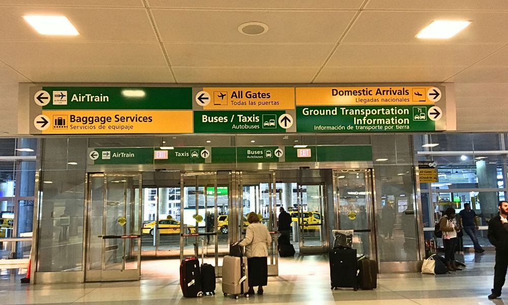 Pasillo de llegadas en el aeropuerto internacional JFK de Nueva York con indicaciones para el transporte hacia el centro de la ciudad.