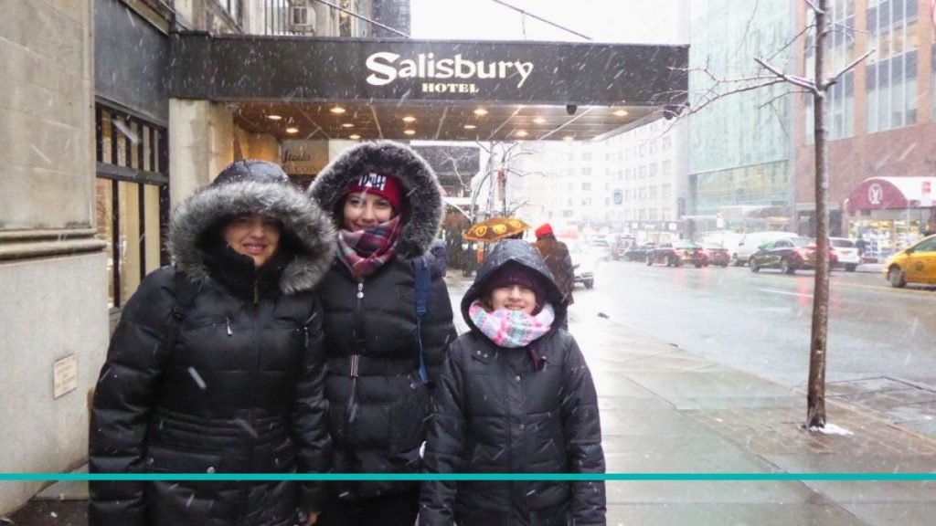 uli con sus hijas frente al cartel del Hotel Salisbury en la calle 57 de Nueva York durante una nevada.