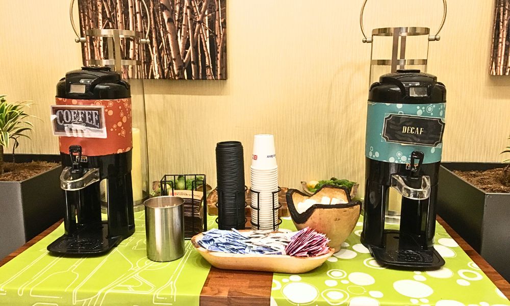 Estación de café y té de cortesía para huéspedes en el lobby decorado del hotel Hilton Garden Inn Midtown Park Avenue.