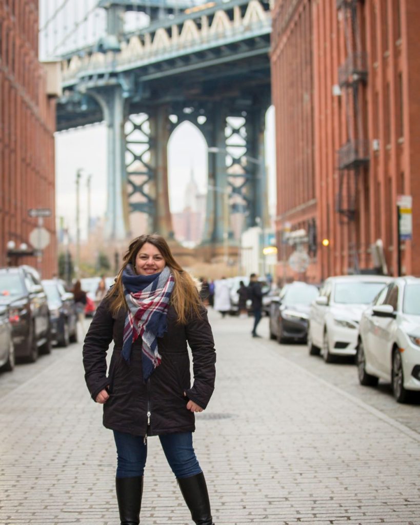 Autora posando en la calle Waters con el Empire State en marcado dentro del Manhattan Bridge en Dumbo, Brooklyn.