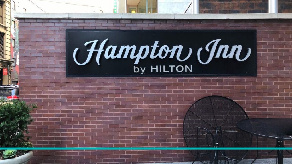 Logotipo del hotel Hampton Inn 35th ST sobre una pared de ladrillo visto en las calles de Manhattan, Nueva York.