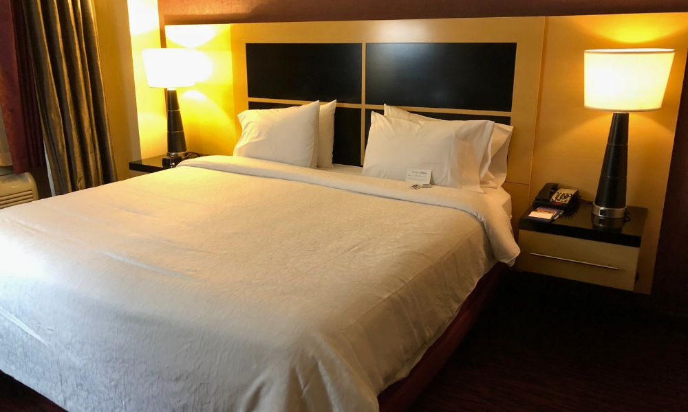 Habitación del hotel Hampton Inn 35th ST con una amplia y cómoda cama King, ideal para descansar después de caminar por Nueva York.