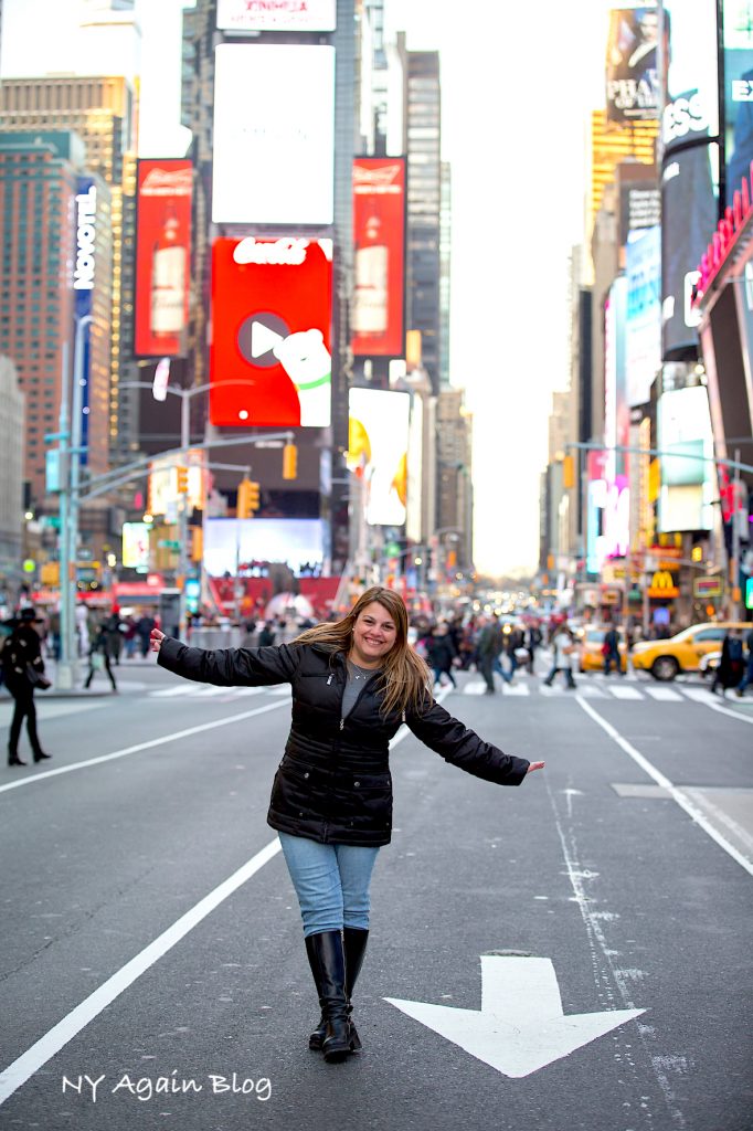 Mujer posando en la calle con Times Square de fondo en Nueva York.