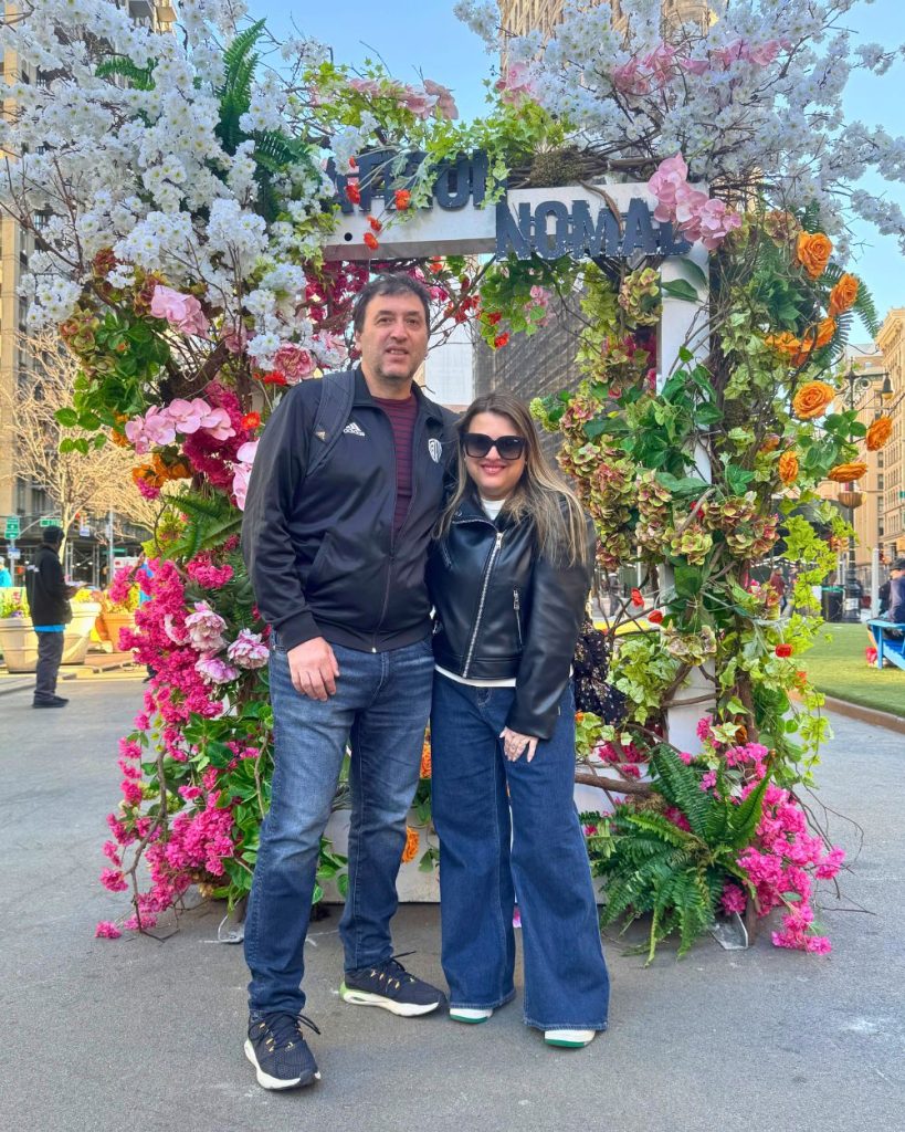 Foto de la autora y marido frente a arreglo floral en flatiron, nomad, con el flatiron building detras.
