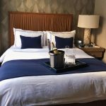 Interior de una habitación del Artezen Hotel con una amplia cama king, diseño boutique e iluminación cálida.