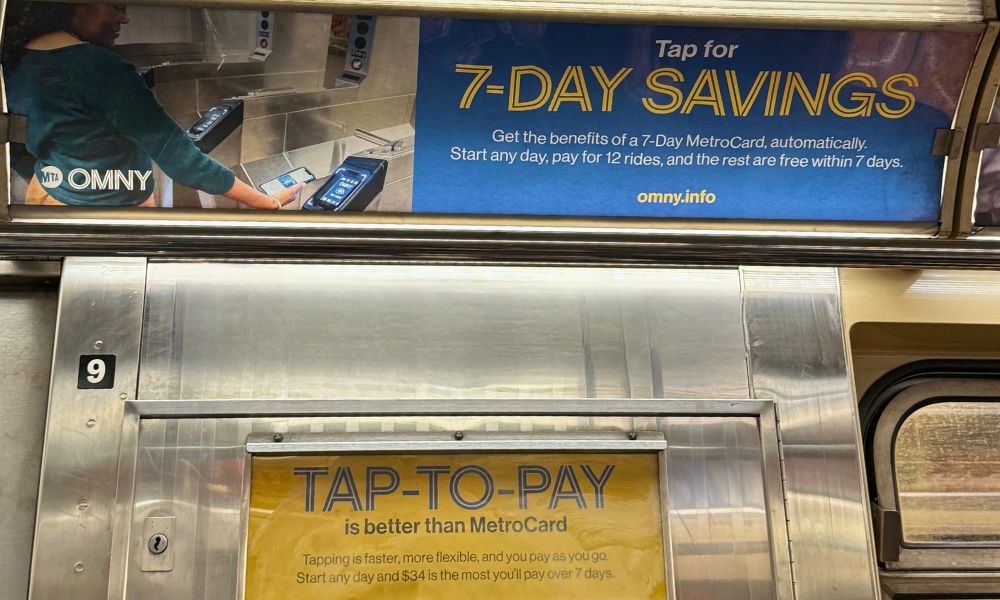 Interior de un vagón de subte de Nueva York con un cartel publicitario de la MTA explicando el sistema de viajes gratis Fare Capping tras 12 trayectos.
