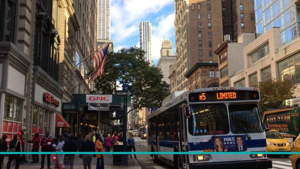 Colectivo M5 de la MTA circulando por una avenida de Manhattan, ideal para la guía de transporte público en Nueva York.