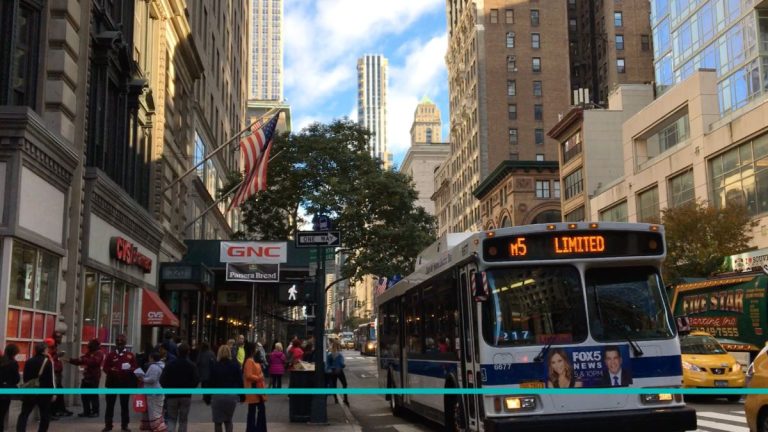 Colectivo M5 de la MTA circulando por una avenida de Manhattan, ideal para la guía de transporte público en Nueva York.